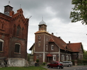 Zdjęcie przedstawia dom w Witnicy. Na pierwszym planie widać fragment budynku gospodarczego, dalej omawiany budynek mieszkalny.                                                                         