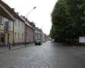 Zdjęcie przedstawia teren starego miasta w Mieszkowicach. Na pierwszym planie widać fragment pl. Wolności. Po lewej stronie są kamienice, po prawej drzewa.                                             