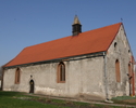 Zdjęcie przedstawia stronę wejścia kościoła zbudowanego z kostki granitowej.                                                                                                                            