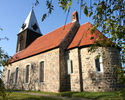 Zdjęcie przedstawia kościół od strony bocznej, który został wykonany z szarej cegły.                                                                                                                    