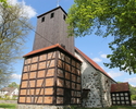 Na zdjęciu znajduję się wieża wykonana z drewna oraz strona wejścia kościoła.                                                                                                                           