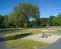 Zdjęcie przedstawia fragment parku z siłownią zewnętrzną przy Gimnazjum Miejskim w Sławnie.                                                                                                             