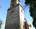 Zdjęcie przedstawia kościół od strony wejściowej, który zbudowany jest z jasnej cegły.                                                                                                                  