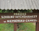 Zdjęcie przedstawia  tablicę informacyjną przy wjeździe do pałacu myśliwskiego                                                                                                                          