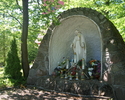 Na zdjęciu widać Grotę z posągiem Najświętszej Marii Panny. Grota on stoi tyłem do chodnika prowadzącego do głównego wejścia kościoła.                                                                  