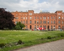 Zdjęcie przedstawia główny budynek Poczty Polskiej w Szczecinie. Na pierwszym planie widać fragment skweru przy pl. Tobruckim, w tle gmach.                                                             