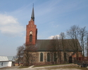 Zdjęcie przedstawia kościół od strony bocznej,  wieża zbudowana jest z czerwonej cegły .                                                                                                                