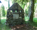 Zdjęcie przedstawia cmentarz przykościelny na Gocławiu. Na pierwszym planie widać poniemiecki nagrobek.                                                                                                 