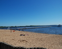Na zdjęciu widnieje plaża przy kąpielisku wraz z molo w Stepnicy.                                                                                                                                       