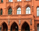 Zdjęcie przedstawia Ratusz Czerwony w Szczecinie. Na pierwszym planie widać arkadowy portyk z czterema rzeźbami, które symbolizują: "Przemysł", "Rolnictwo", "Żeglarstwo" i "Wiedzę".                   
