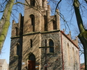 Zdjęcie przedstawia kościół zbudowany z szarej cegły od strony wejścia.                                                                                                                                 