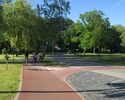 Zdjęcie przedstawia fragment parku  z wyznaczonymi ścieżkami i drogą rowerową przy Gimnazjum Miejskim w Sławnie.                                                                                        