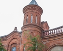Zdjęcie przedstawia główny budynek Poczty Polskiej w Szczecinie. Na pierwszym planie widać wieżę.                                                                                                       