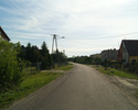 Zdjęcie przedstawia główną drogę we wsi Boleszewo wraz z zabudowaniami.                                                                                                                                 