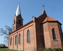 Zdjęcie przedstawia kościół od bocznej strony, który zbudowany został z czerwonej cegły.                                                                                                                