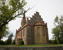 Zdjęcie przedstawia kościół od bocznej strony, usytuowany jest pośród zieleni.                                                                                                                          