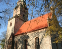 Zdjęcie przedstawia kościół od strony bocznej, który zbudowany jest z jasnej cegły.                                                                                                                     