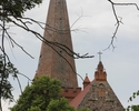 Zdjęcie przedstawia teren starego miasta w Trzcińsku-Zdroju. Na pierwszym planie widać wieżę kościoła.                                                                                                  