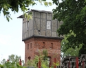 Zdjęcie przedstawia wieżę kolejową w Trzcińsku-Zdroju. Na pierwszym planie widać szczyt wieży w otoczeniu drzew.                                                                                        