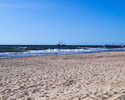 Zdjęcie przedstawia plażę w Darłówku Zachodnim. W okresie letnim miejsce to jest kąpieliskiem z obsługą ratowników.                                                                                     