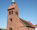 Zdjęcie przedstawia stronę wejścia oraz ścianę boczną kościoła, który został zbudowany z cegły.                                                                                                         