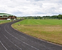 Zdjęcie przedstawia stadion klubu sportowego Polonii Płoty, wraz z widoczną po lewej stronie halą sportową oraz dwoma boiskami treningowymi w tle                                                       