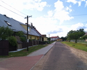 Zdjęcie przedstawia główną drogę we wsi Borkowo wraz z zabudowaniami.                                                                                                                                   