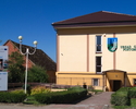 Zdjęcie przedstawia budynek Urzędu Gminy w Postominie, w którym mieści się Biblioteka Publiczna. na zdjęciu widoczne jest wejście do biblioteki.                                                        