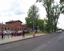 Zdjęcie przedstawia dojazd do dworca kolejowego i autobusowego w Sławnie. Budynek dworca znajduje się z lewej strony drogi.                                                                             