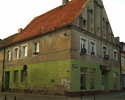 Zdjęcie przedstawia narożny zabytkowy dom przy ul. Powstańców Warszawskich 15 w Darłowie.                                                                                                               