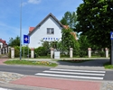 Zdjęcie przedstawia front budynku filii Urzędu Pocztowego w Karnicach wraz z bramą wejściową widoczną po lewej stronie                                                                                  