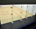 Zdjęcie przedstawia widok na boisko do squasha wraz z drzwiami prowadzącymi na kort                                                                                                                     