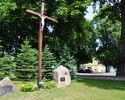 Zdjęcie przedstawia krzyż i głazy pamiątkowe stające w miejscu dawnego cmentarza przykościelnego w Karnicach                                                                                            