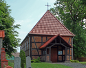 Zdjęcie przedstawia widok kościoła w Buślarach wraz z tablicami nagrobnymi w lewej części kadru.                                                                                                        