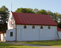 Zdjęcie przedstawia kościół w Głodzinie z widocznym wejściem i ścianą boczną.                                                                                                                           