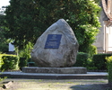 Zdjęcie przedstawiające pomnik pamiątkowy poświęcony Piłsudskiemu, ma on formę tablicy z popiersiem umieszczonej na głazie narzutowym                                                                   