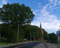 Zdjęcie przedstawia główną drogę we wsi Bukowo Morskie. Z lewej strony drogi widoczny jest kościół.                                                                                                     