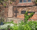 Zdjęcie przedstawia fragment lapidarium przy kościele pw. Matki Bożej Częstochowskiej w Darłowie.                                                                                                       