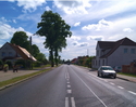 Zdjęcie przedstawia główną drogę we wsi Warszkowo wraz z zabudowaniami.                                                                                                                                 
