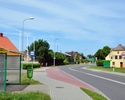 Zdjęcie przedstawia zabudowę mieszkalną wraz z przystankiem autobusowym widzianą z drogi prowadzącej z Gryfic do nadmorskich miejscowości                                                               