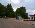 Zdjęcie przedstawia główną drogę we wsi Rusinowo. Na zdjęciu z prawej strony drogi widoczny jest przystanek autobusowy oraz budynek Ochotniczej Straży Pożarnej.                                        