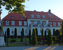 Zdjęcie przedstawia pałac w Modrzewcu od strony wschodniej, na pierwszym planie widoczny zadbany ogród.                                                                                                 