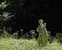 Zdjęcie przedstawia fragment parku dworskiego w Lekowie. Widoczna figura panny pracującej w ogrodzie.                                                                                                   