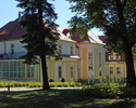 Zdjęcie przedstawia pałac w Krzecku, widoczny front i przeszklona ściana boczna.                                                                                                                        