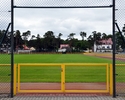 Zdjęcie przedstawie żółtą bramę wejściową na płytę boiska                                                                                                                                               