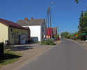 Zdjęcie przedstawia zabudowania, sklep, przystanek autobusowy w Powalicach.                                                                                                                             