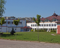 Zdjęcie przedstawia kompleks Gimnazjum w Połczynie-Zdroju, w lewej części zachodnie skrzydło to hala widowiskowo-sportowa. Widok od strony parkingu.                                                    