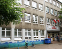 Zdjęcie przedstawia Centrum Kształcenia Sportowego. Przed szkołą znajdują kolorowe stojaki na rowery.                                                                                                   