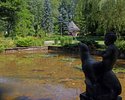 Zdjęcie przedstawia zbliżenie na jedną z fontann w kształcie chłopca siedzącego na foce w  parku w Połczynie-Zdroju.                                                                                    