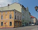 Zdjęcie przedstawia budynki na skrzyżowaniu ulic Grunwaldzkiej i 5 Marca w Połczynie -Zdroju. W głębi  słynny sklep Słodka Dziurka, dawniejsze delikatesy.                                              